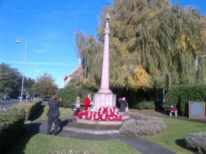 The Deputy Mayor of Kingston inspects the wreaths at the Surbiton memorial after the ceremony.